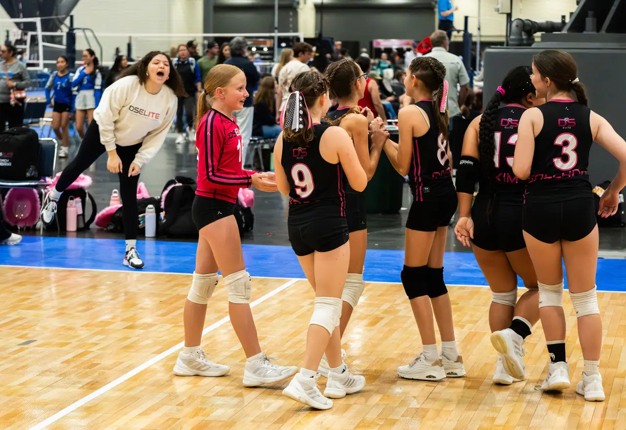 A younger DS Elite team in black uniforms high-fiving in a line